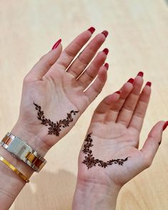 two hands with henna tattoos on their palms