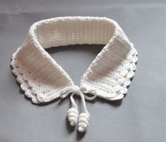 a white crocheted collar on a gray surface