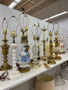 many lamps are lined up on a shelf