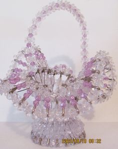 a pink and clear beaded basket on a white surface