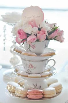 a stack of tea cups filled with pink and white flowers