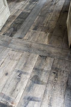 an old wood floor in a kitchen with white cabinets