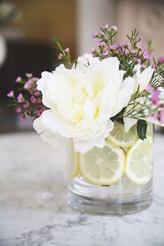 a glass vase filled with lemon slices and flowers