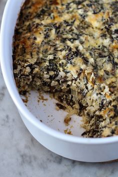 a casserole dish with spinach and cheese in it sitting on a table