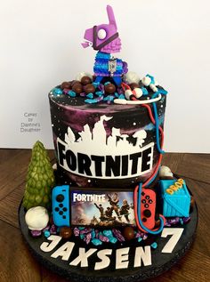 a birthday cake decorated with video games and gaming related items, including a controller for the game fortnite