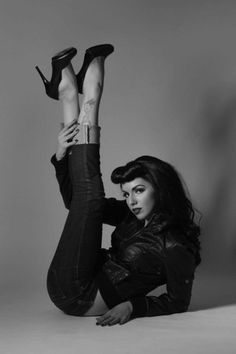 a black and white photo of a woman laying on the ground with her legs up