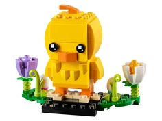 a yellow lego duck sitting on top of a flower