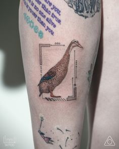 a person with a tattoo on their leg that has a duck in front of it