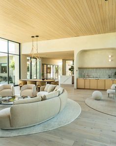 a living room filled with furniture and large windows