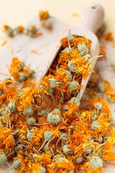 dried flowers in a wooden scoop on a table