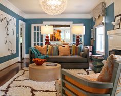 a living room filled with furniture and a chandelier hanging from the light fixture