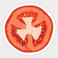 a tomato cut in half on top of a white plate with red and yellow dots