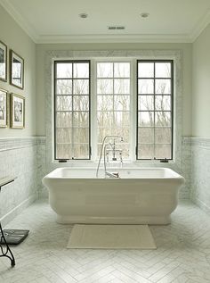 a white bath tub sitting next to two windows