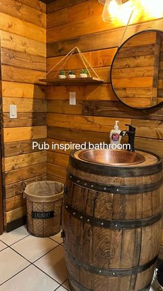 a bathroom with a wooden barrel sink and mirror on the wall next to two buckets