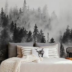 a bedroom with a deer head on the wall and fog in the trees behind it