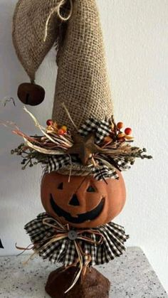 a scarecrow pumpkin sitting on top of a table next to a burlock