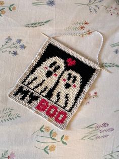 a cross stitch ornament with two brides on it sitting on a bed