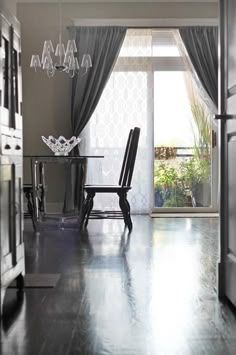 an open door leading to a dining room with a table and chairs in front of it