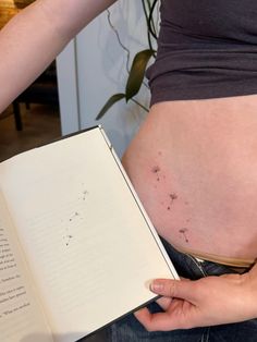 a pregnant woman is holding an open book