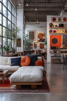 a living room filled with lots of furniture and large windows in the back drop off wall