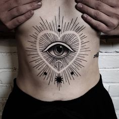 a man's stomach with an all seeing eye tattoo on it