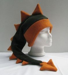 a white mannequin head with an orange and black hat on top of it