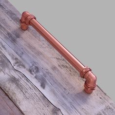 a close up of a metal handle on a wooden doorknott with wood planks in the background