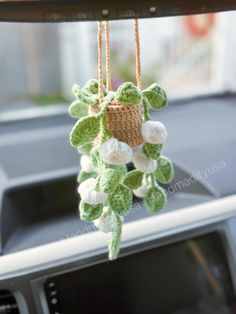 a crocheted plant hanging from the dashboard of a car