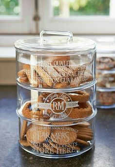 three clear containers filled with cookies on top of a counter