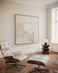 an empty room with two chairs and a painting on the wall