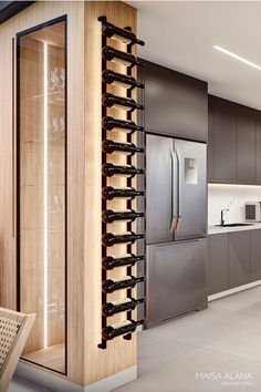 a modern kitchen with stainless steel appliances and wood accents, along with wine glasses racks