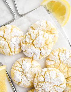 lemon cookies with powdered sugar on top and two lemons next to them,