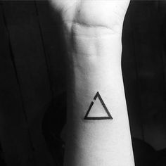 a small triangle tattoo on the wrist