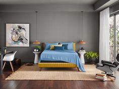 a bedroom with gray walls and blue bedding in the middle, along with a rug on the floor