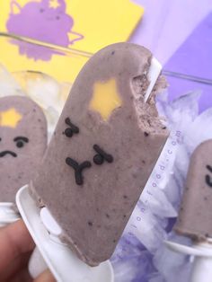 two ice cream pops with faces drawn on them