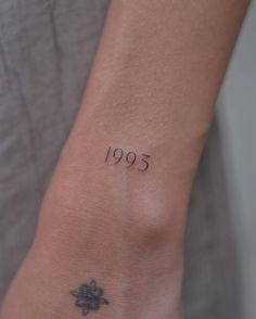 a woman's wrist with a small tattoo on the left side of her arm