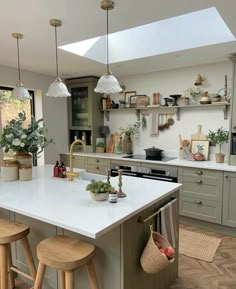 a kitchen with two stools and an island in front of the counter top is filled with potted plants