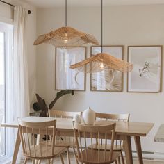 a dining room table with chairs and pictures on the wall