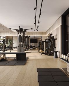 an empty gym with exercise equipment on the floor and hard wood floors in front of it