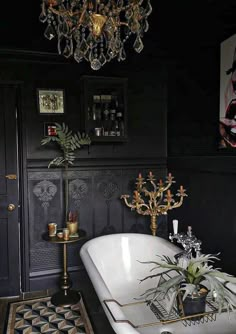 a bathtub in a bathroom with a chandelier hanging from it's ceiling