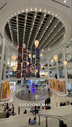 the inside of a shopping mall with lots of lights hanging from it's ceiling