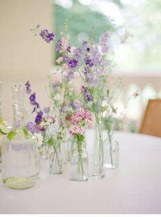 several vases filled with flowers sitting on top of a table