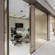 an office with glass walls and sliding doors that lead to the other side of the room