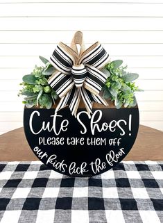 a black and white checkered table cloth with a wooden sign that says cute shoes please care them off