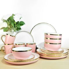 pink and gold dinnerware set with flowers in vase