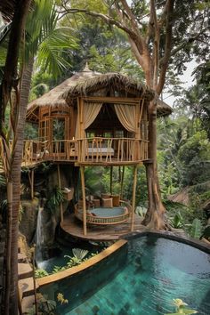 a tree house in the middle of some trees with a pool and waterfall below it