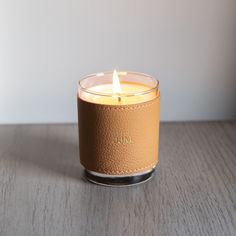 a lit candle sitting on top of a wooden table