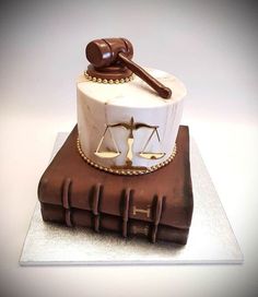 a judge's gaven and scale cake sitting on top of an old book