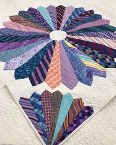 a close up of a quilt with many different colored ties on it