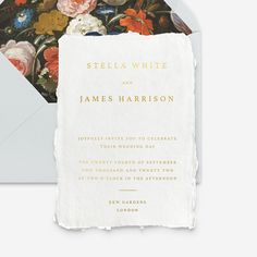 a wedding card with flowers on it and a envelope in the middle, sitting next to an envelope that says stella white and james harrison